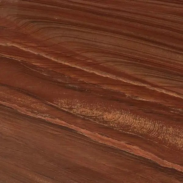 Close-up of red wood grain sandstone showing red-brown ground with flowing wood-like bands and lighter streaks