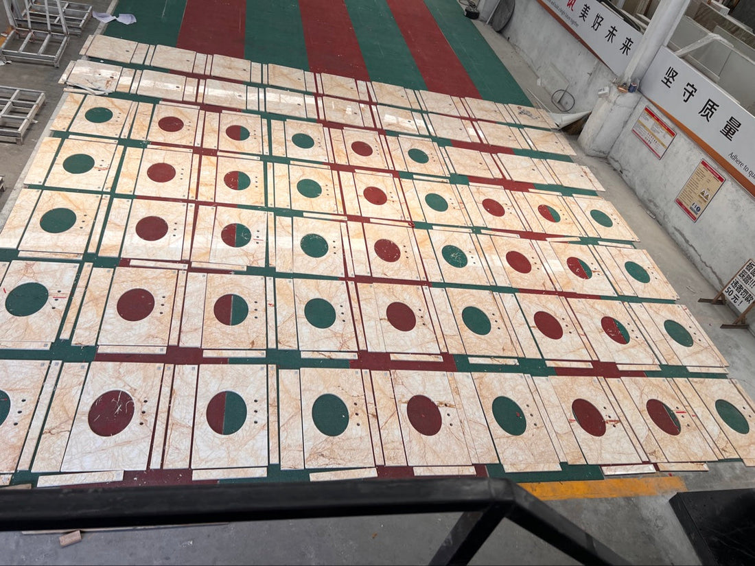 Overhead view of hundreds of Golden Spider marble vanity tops dry-laid in rows at the factory for a hotel project