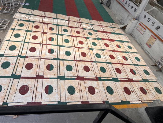 Overhead view of hundreds of Golden Spider marble vanity tops dry-laid in rows at the factory for a hotel project
