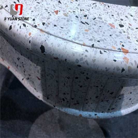Close-up of a polished white terrazzo countertop edge with multicolour stone chips