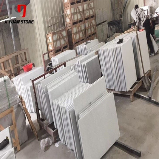 White granite slabs in racks at the Ji Yuan Stone factory, ready to be cut into driveway pavers