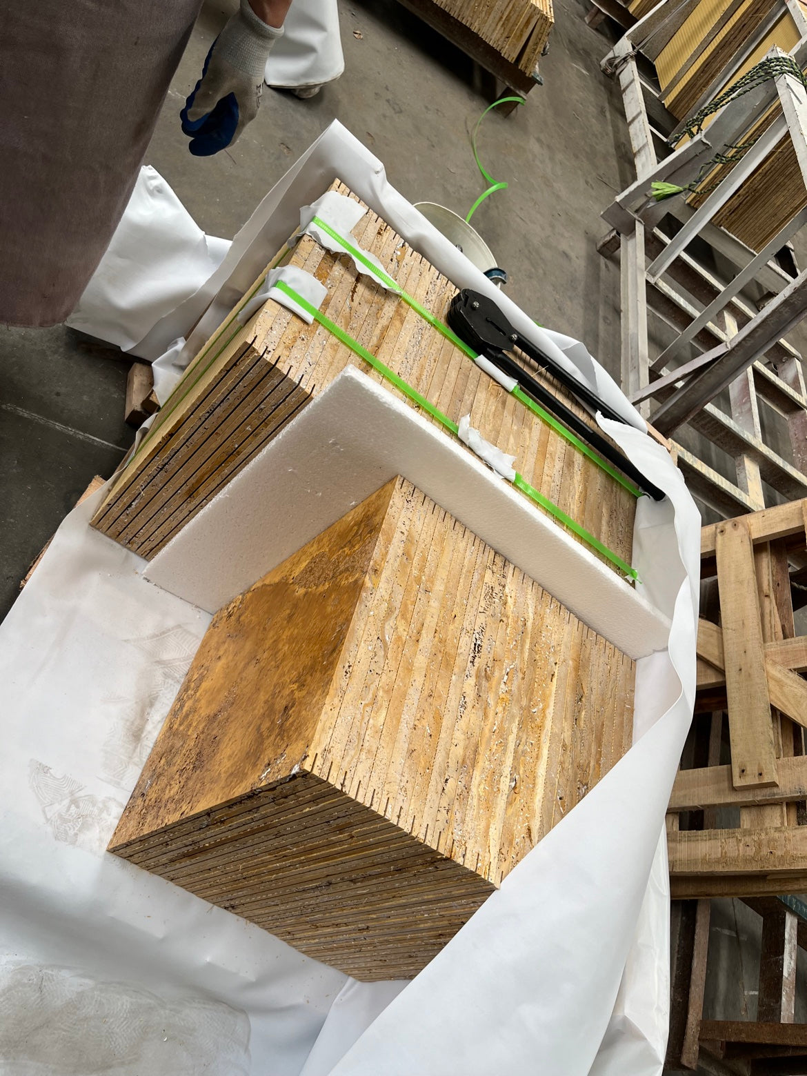 Packed golden travertine tile bundles with foam protection in wooden crate