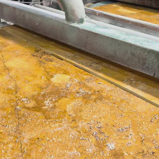 Golden travertine slabs on the polishing line at the factory