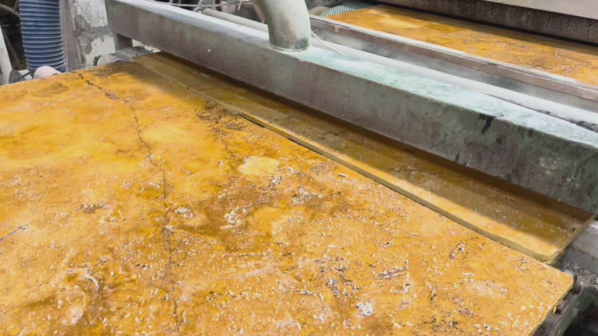 Golden travertine slabs on the polishing line at the factory